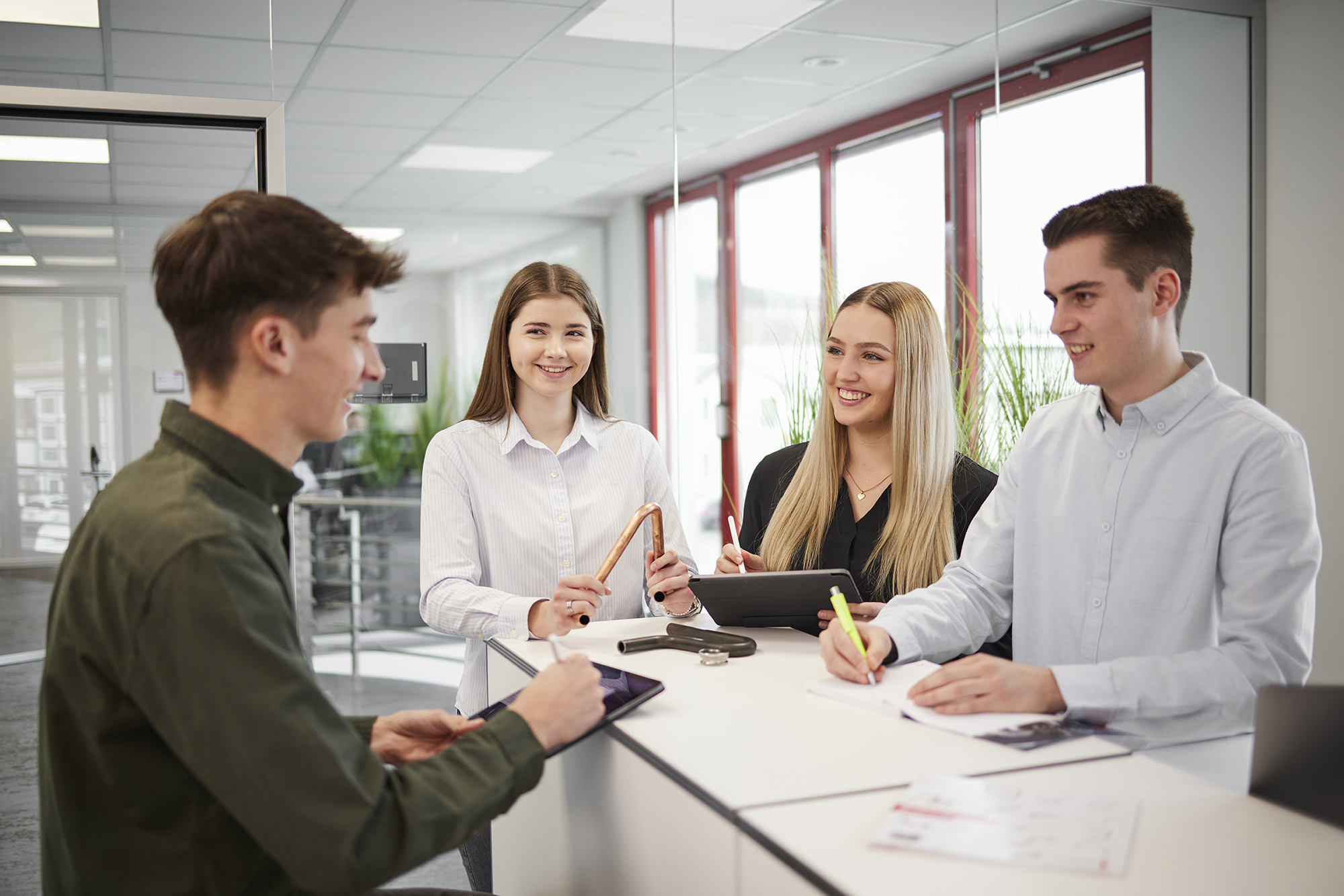 Auszubildende Industriekaufleute im Büro bei Besprechung und Organisation von Aufträgen.