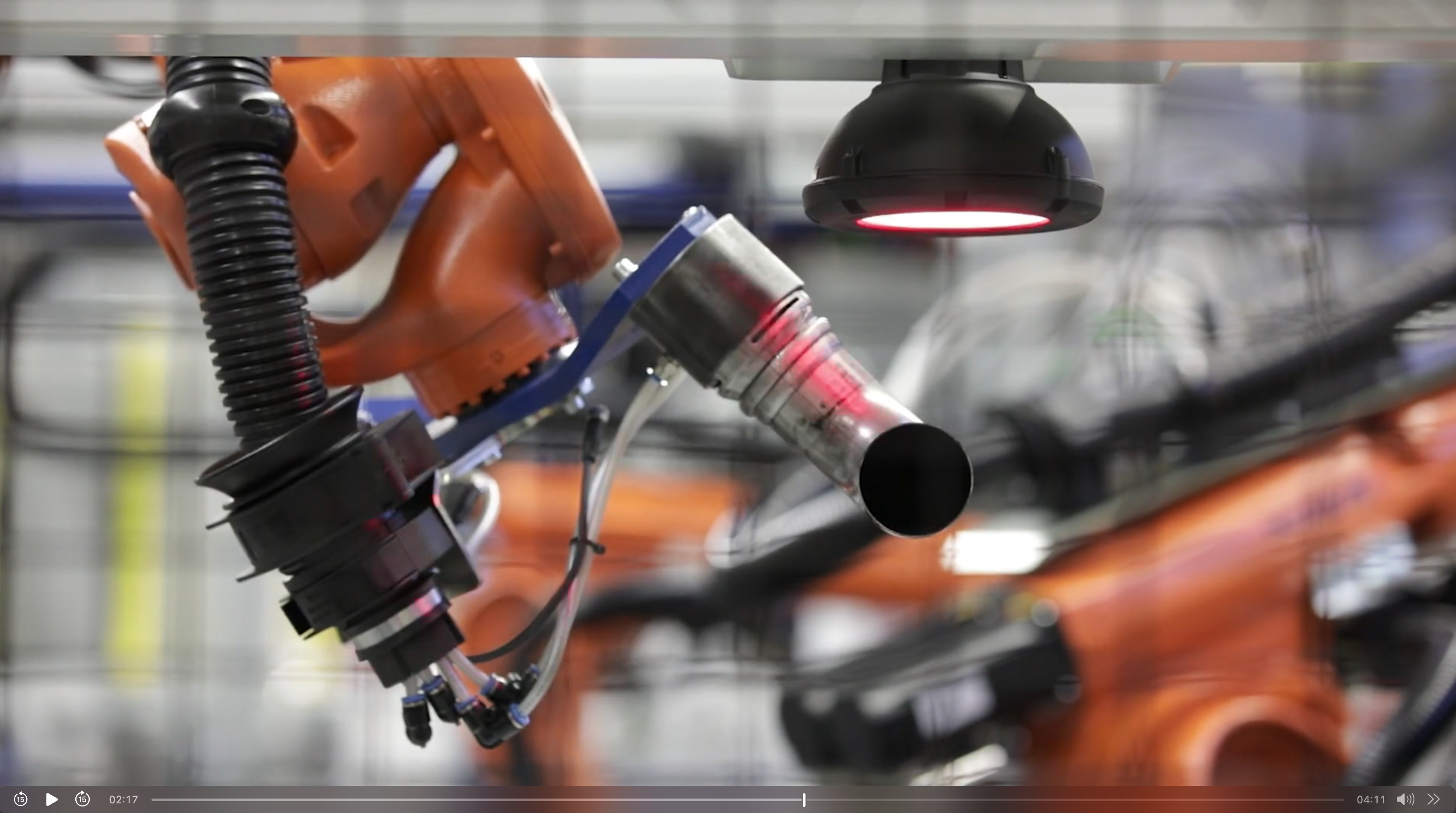 Industrieroboter prüft Metallrohr mit Sensorsystem in automatisierter Automotive-Fertigungszelle.