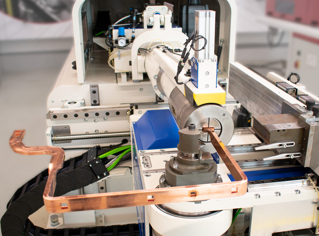 Maschine bearbeitet Kupfer-Stromschiene (Busbar) durch präzises Biegen in automatisierter Fertigungsanlage.