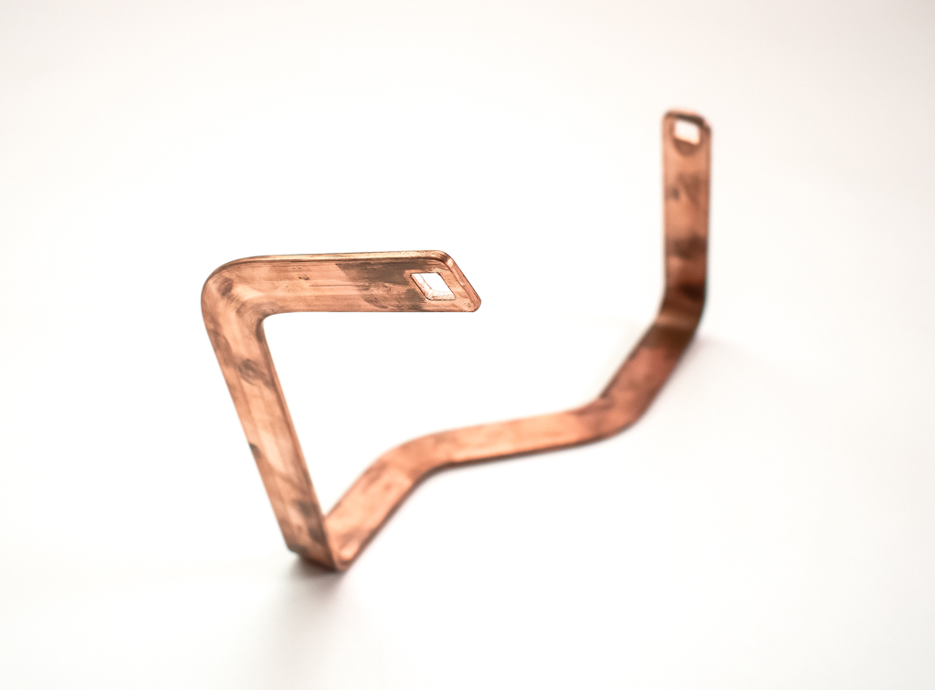 Gebogene Kupfer-Stromschiene (Busbar) mit gestanzten Kontaktflächen für elektrische Anwendungen.