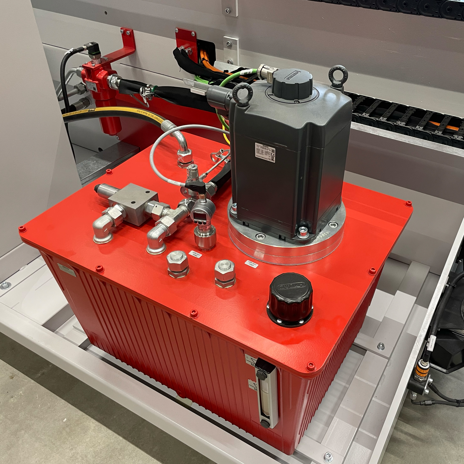 Hydraulikaggregat mit Servomotor und Ventiltechnik auf einer CNC-Rohrbiegemaschine zur präzisen Steuerung des Hydraulikdrucks im industriellen Biegeprozess.
