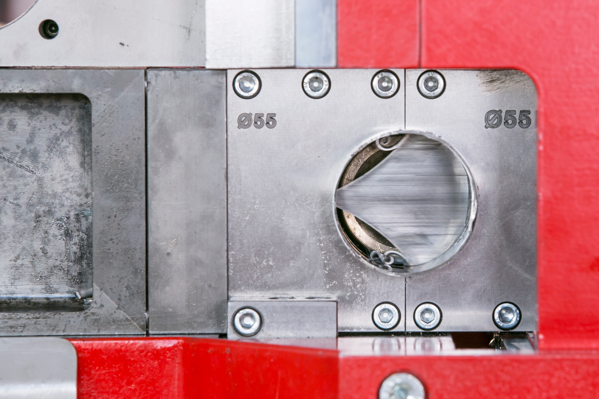 Detailaufnahme der CNC-Rohrbearbeitungsmaschine t bend POWERLINE 60 von transfluid beim Schneiden eines Metallrohrs mit integriertem Rohrschneidwerkzeug.