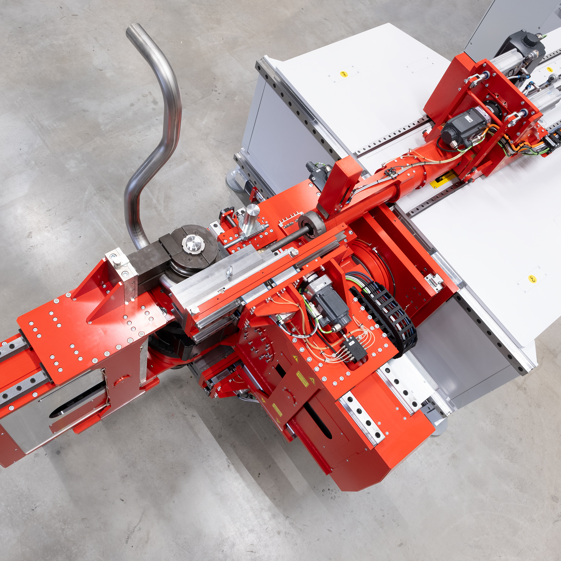 Draufsicht auf CNC Rohrbiegemaschine transfluid t bend VARIOLINE 60 beim Biegen eines Metallrohrs.
