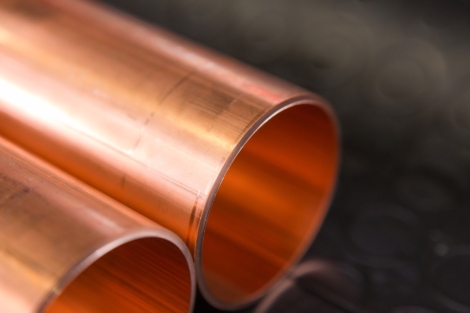 Nahaufnahme von zwei Kupferrohren mit glatter, gratfreier Schnittkante für industrielle Anwendungen und Rohrbearbeitung.