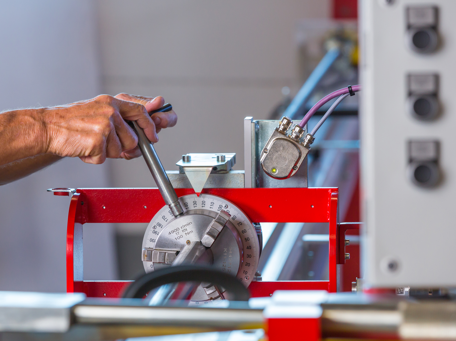 Bediener stellt Spannsystem einer CNC-Rohrbiegemaschine zur präzisen Metallrohrbearbeitung ein.