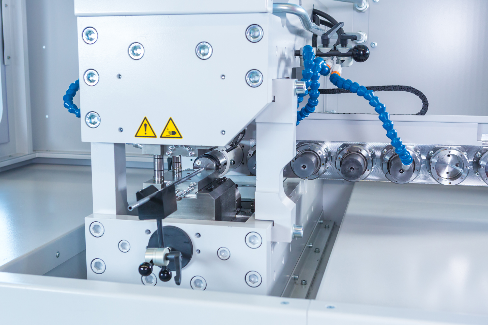 Rohrumformmaschine t form BOOSTLINE 32 von transfluid mit mehreren Werkzeugstationen zur axialen Bearbeitung von Metallrohren.