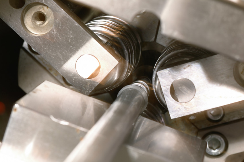 Rollwerkzeuge einer Rohrenden-Umformmaschine Typ MULTILINE formen das Ende eines Metallrohres präzise.